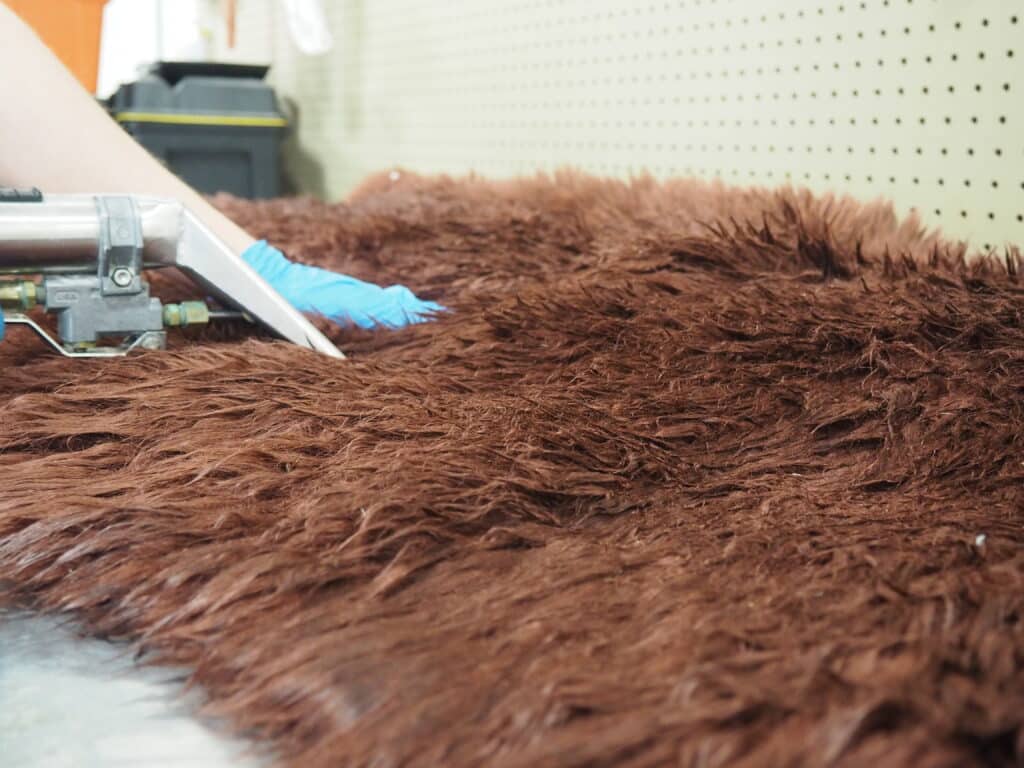 Our Rug Plant Manager and Master Rug Cleaner cleaning a Cowhide Rug.